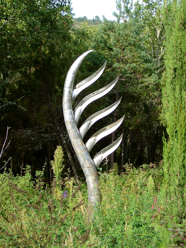 Inspired by a palm tree , this sculpture in stainless steel graces the wilds around an otherwise very ordered garden